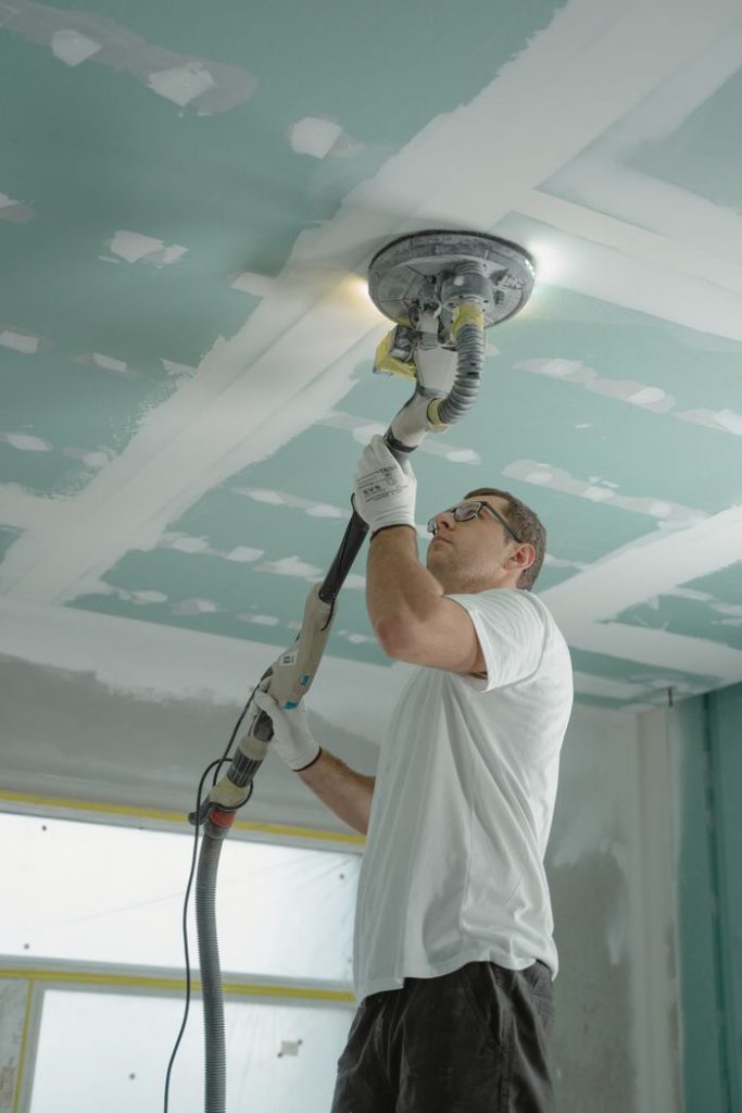 Sanding a ceiling smooth during popcorn ceiling removal in Fort Erie