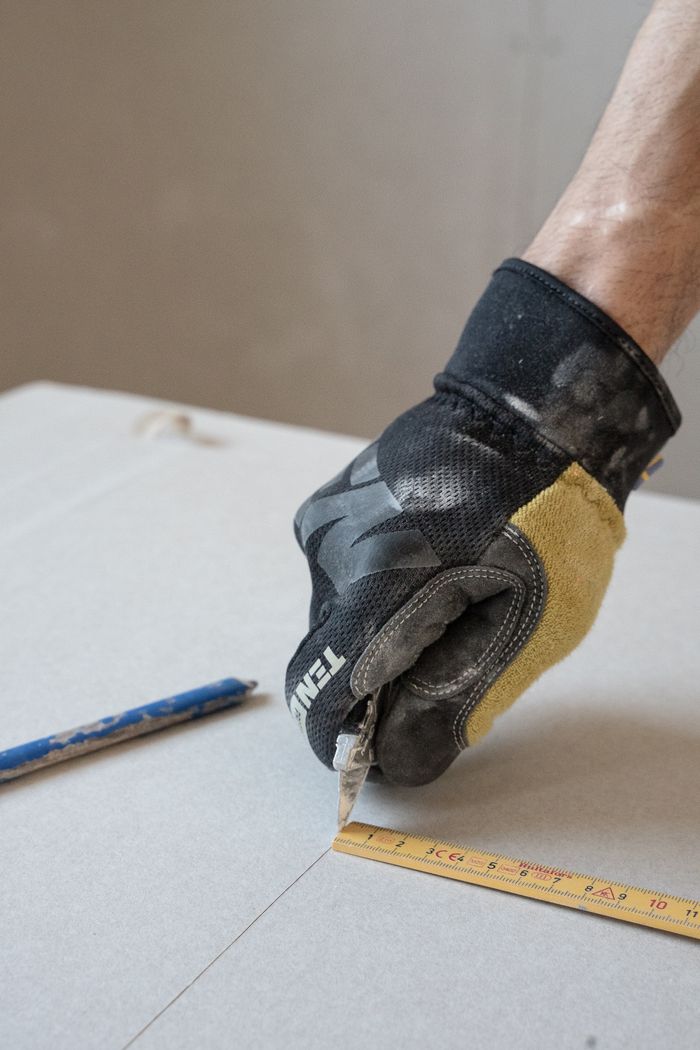 Cutting a drywall patch to size for a drywall repair in Fort Erie